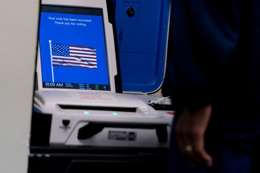 FILE - A voter submits their ballot at an early voting location in Alexandria, Va., Monday, Sept. 26, 2022. Election officials in Virginia have announced plans to withdraw the state from a bipartisan effort aimed at ensuring accurate voter lists and combating fraud that has been ensnared in conspiracy theories that have erupted since the 2020 presidential election. (AP Photo/Andrew Harnik, File)